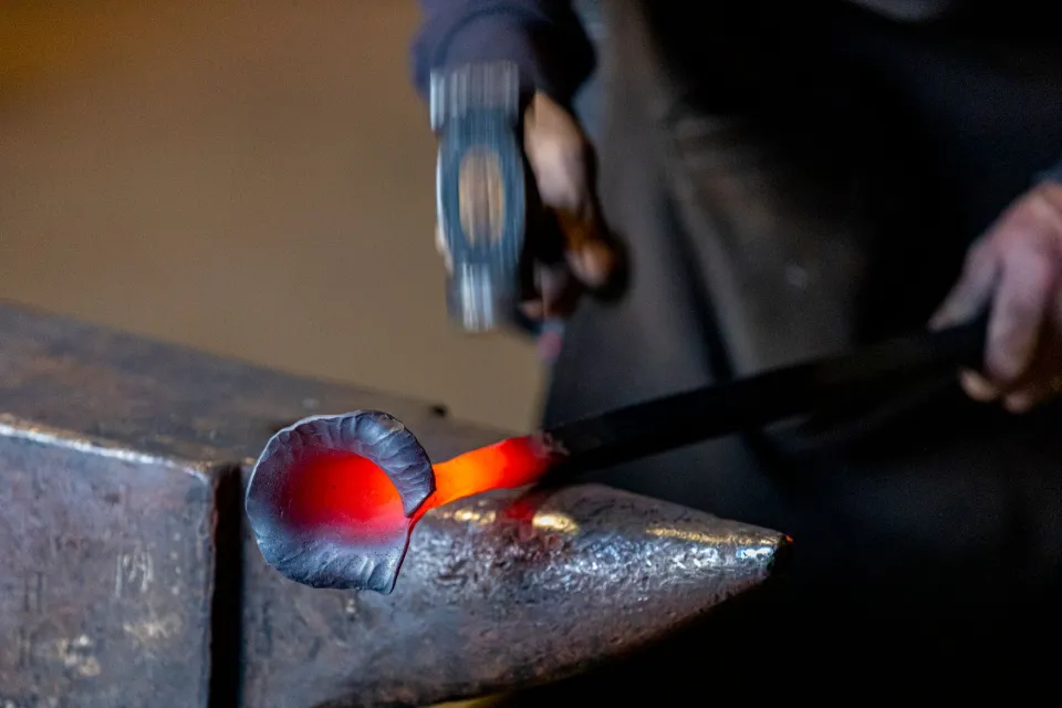 Volute de fer rougie au feu façonnée au marteau sur l'enclume d'un ferronnier