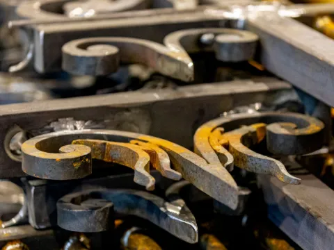 Volutes et feuilles d'acier forgé en cours de fabrication sur l'établi de l'atelier